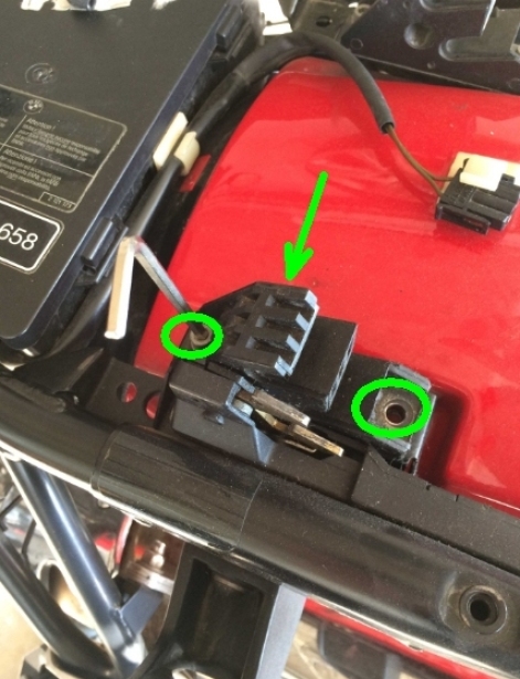 Schrauben der Sitzbankhalterung lösen und diese abnehmen. Der grüne Pfeil zeigt die zweite Schraube der Verriegelung.